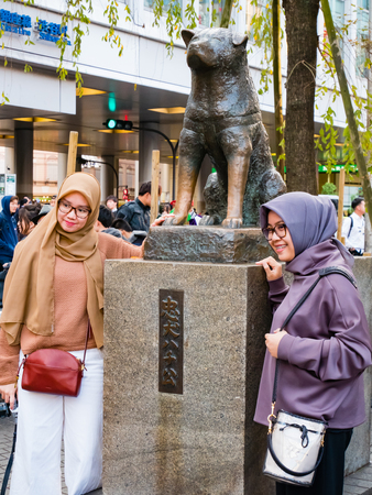 Tokyo, Japan - October 31, 2018:  Tourists taking pictures with Hachiko Memorial statue. The story of Akita dog became legend at Shibuya Hachiko Exit in Shibuya train station  in Tokyo, Japan.のeditorial素材