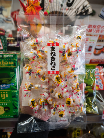 Kawaguchi, Japan - November 1, 2018: Hand holding Japanese snack in souvenir shop at Kawaguchiko, Japanのeditorial素材