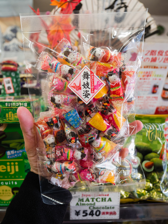 Kawaguchi, Japan - November 1, 2018: Hand holding Japanese snack in souvenir shop at Kawaguchiko, Japanのeditorial素材