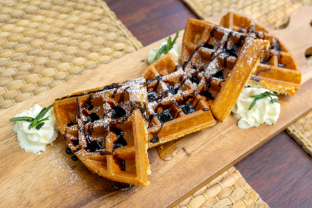 Close up waffles with chocolate and icing sugar on a plateの写真素材