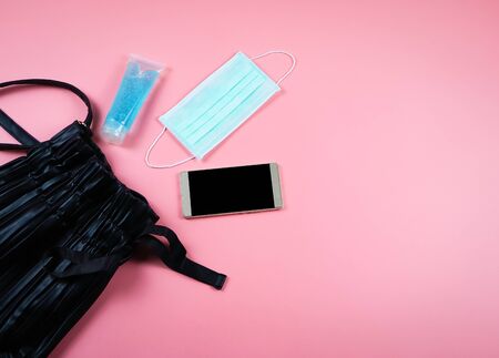Top view or flat lay of woman's bag accessories with  hygienic mask and sanitizer gel , Protection...