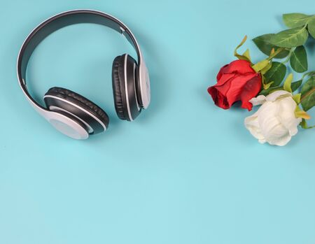 Love songs concept , headphons with red and white roses on blue background with copy space.の写真素材