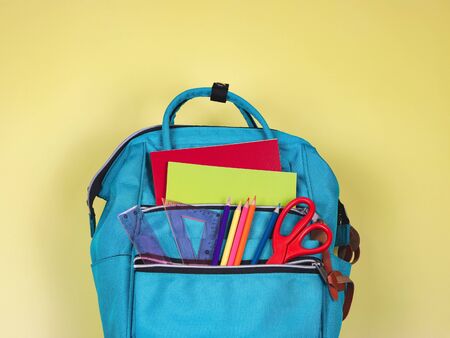Back to school concept.Top view of backpack with school supplies on yellow background with copy space.の写真素材