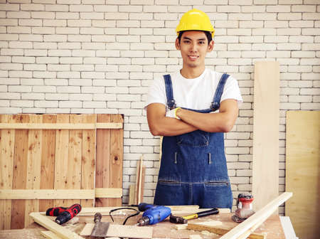 Asian young and handsome male carpenter using Water Level Gauge Ruler in the room with wood...