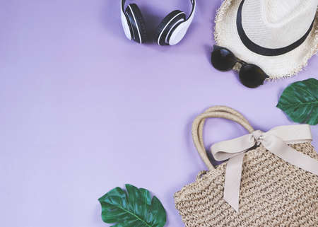 Travel and summer holiday concept, Women's vacation accessories items on purple  background with tropical monstera leaves.top view with copy space.の写真素材