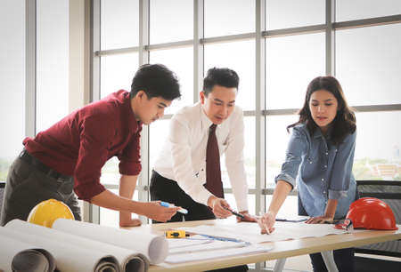 Three construction workers , a female architect and two male engineers discussing about the project...