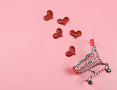 Top view or flat lay of red glitter hearts split out from shopping cart on pink background with copy space.Valentine's day , love conceptの写真素材