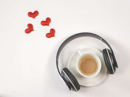 Top view or Flat lay of coffee cup cover with headphones on white background with red glitter hearts decoration. Love song ,Music and coffee relaxing time concept.の写真素材