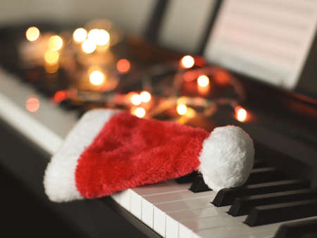 Front view of Christmas  Santa claus hat on electric piano keyboard with Christmas lights decoration...