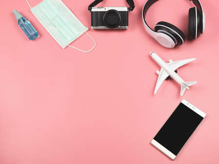 Top view or flat lay of airplane model, camera, headphones, mobile phone, protective face mask and...