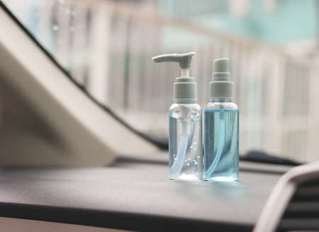 Close up image of alcohol spray bottle and alcohol sanitizer hand gel on car console.  prevention and new normal concept.の写真素材
