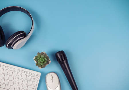 Top view or flat lay of computer keyboard  mouse, headphones, microphone and cactus on blue background with copy space. Online learning, online teaching, podcast background.の写真素材