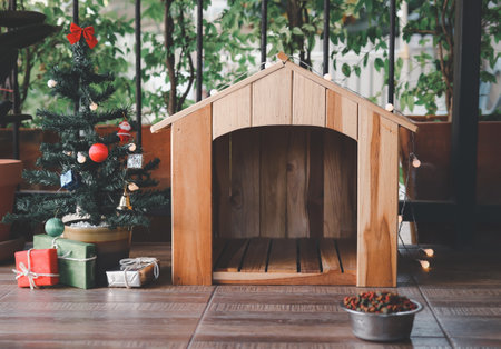 Front view of wooden pet's house with Christmas tree,  gift boxes and food bowl.の写真素材