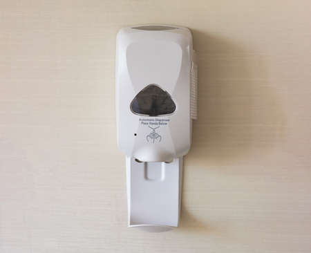 Automatic alcohol gel dispenser  on the wall. Covid19 prevention and new normal concept.