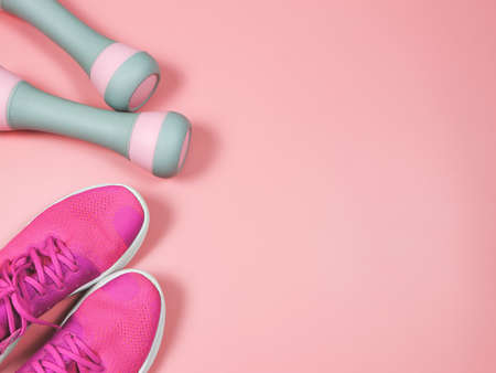 Top view or flat lay of pink sneakers or sports shoes and gray pink dumbbells on pink background with copy space. Sports and active lifestyle concept.の写真素材