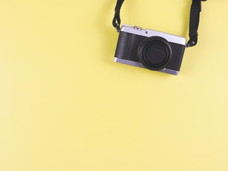 Top view or flat lay of digital camera on yellow  background with copy space. Photo and memory concept.の写真素材