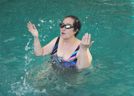 Portrait of Happy and healthy Asian senior woman splash water in swimming pool.の写真素材