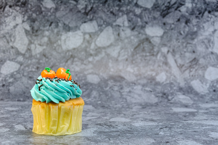 One Bluecream and Pumpkins on top of cupcakd on gray background
