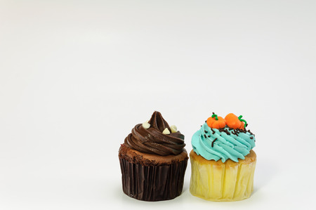 Dark chocolate and pumpkin face cupcakes on white backgroundの写真素材
