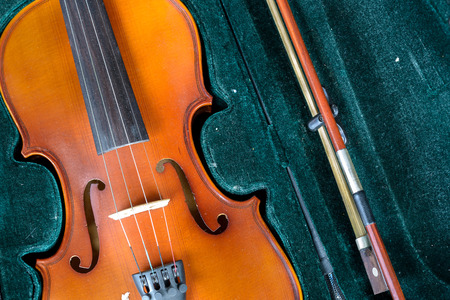 Detail of old fashioned violin on green velvet background.の写真素材