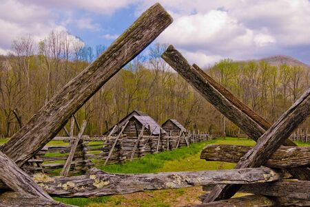 Historic eighteenth century wooden farm buildings as seen through an old fence post  in early springat the Great Smoky Mountain National Park.の写真素材