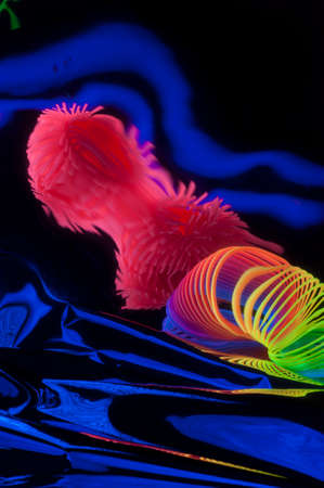 Fuzzy and circular objects which are distorted are viewed in a close-up and are lit with fluorescent colors against a deep blue background.の写真素材