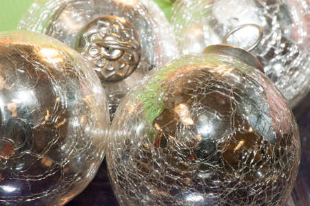 Bright, shiny, silver-colored metallic balls or Christmas decorations are viewed close-up and in a small grouping.の写真素材