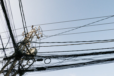bunch of electrics and communication wires in streetの写真素材