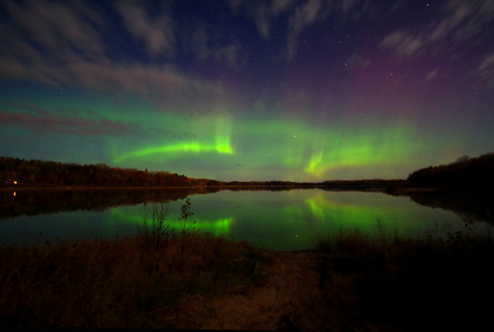Aurora / northern lights reflecting over a lake in Nevis, Minnesotaの写真素材