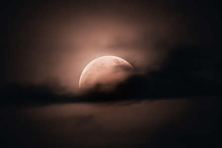 Cloud-covered supermoon during total moon eclipse