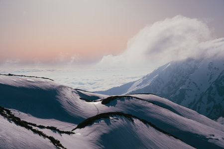 Mountain landscape with snow and clouds at sunset. Caucasus Mountains, Georgia, region Gudauri.