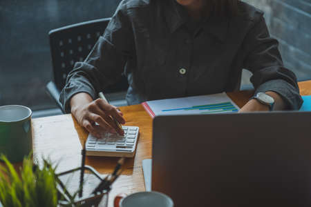 Cropped shot of young female entrepreneur working on financial report.の写真素材