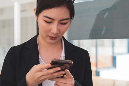 Cropped shot of professional female in business casual using smart phoneの写真素材