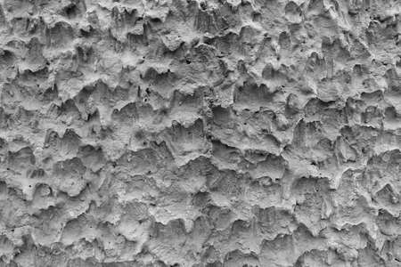 The surface of the cement wall makes it rough. It's an unusual texture and comes in black and white.