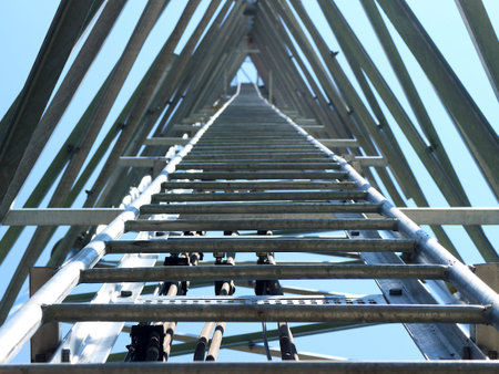 The photograph offers an upward perspective of a telecommunications tower's internal structure. The...