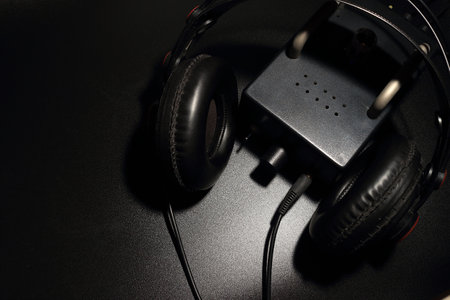 The full size headphones are placed with a tube preamp on a black background.