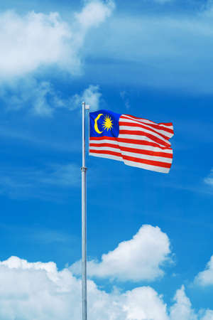 Malaysia flag on a pole against blue sky.の写真素材