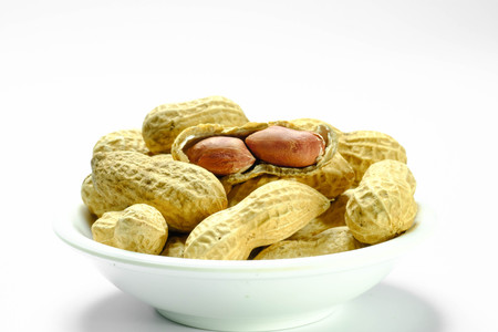 Peanuts isolated on the white background. Close up in blowの写真素材