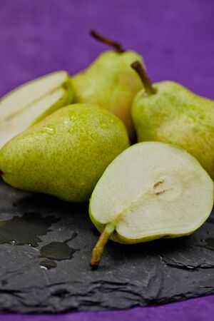 Fresh ripe pears in front of a purple backgroundの写真素材