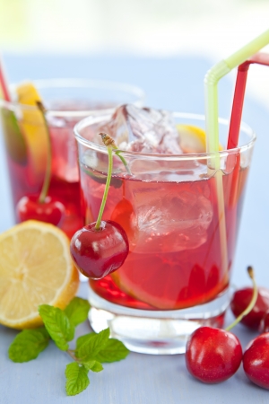 Homemade  lemonade   iced tea with fresh cherries, lemons and mintの写真素材