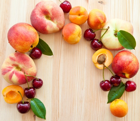 Wooden background with a frame of fresh fruitsの写真素材