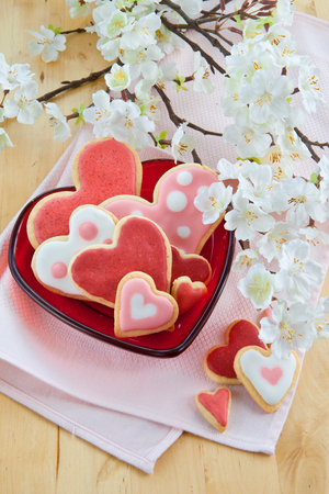 Colorful cookies in heart-shapes on red plateの写真素材