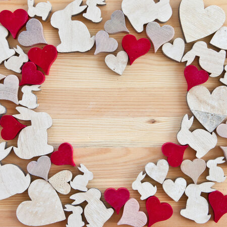 Rustic wooden background with hearts and easter bunnies