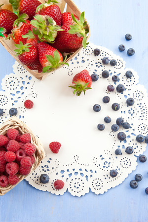 Variety of strawberries, raspberries and blueberries on blue backgroundの写真素材