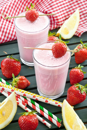 Milk shake with fresh strawberries with colorful strawsの写真素材