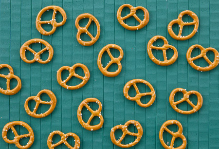 Little pretzels on green painted wooden backgroundの写真素材