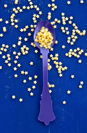 Yellow sugar stars with vintage spoon on blueの写真素材