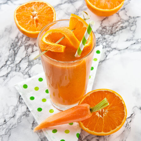 Fresh orange and carrot smoothie on marbled の写真素材
