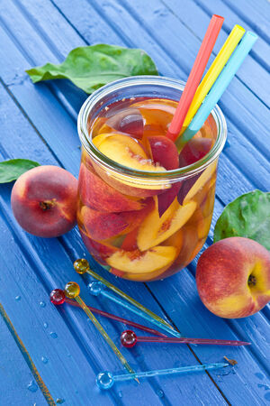 Homemade iced tea with fresh peaches in vintage jarの写真素材