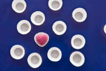 Pink heart shaped chocolate on blue backgroundの写真素材